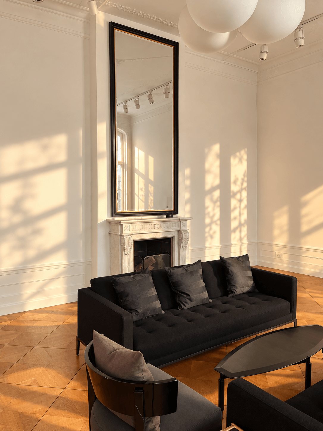 Salon corner with mirror, fireplace and black sofa
